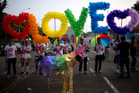 Revelers hold balloons, representing the colors of a rainbow, to form the word, "Love" during the annual gay pride parade in Lima, Peru, Saturday, June 27, 2015. (AP Photo/Rodrigo Abd) ORG XMIT: ABD107